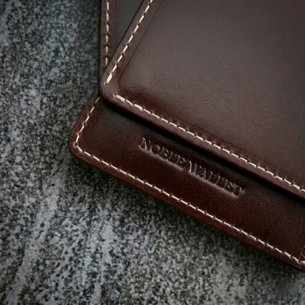Brand new brown full grain leather slim wallet with clean surface and sharp edges, showcasing premium minimalist design before use.